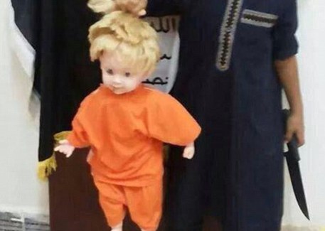 Bimbo decapita una bambola su Twitter, come durante l'esecuzione di James di Foley. C'è anche la bandiera dell'Isis © Ansa
