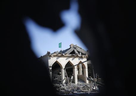 Una bandiera di Hamas sventola su una moschea distrutta © EPA