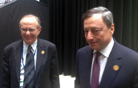 Draghi (d) e Padoan a margine lavori Fmi a Washington, 17 aprile 2015 © ANSA