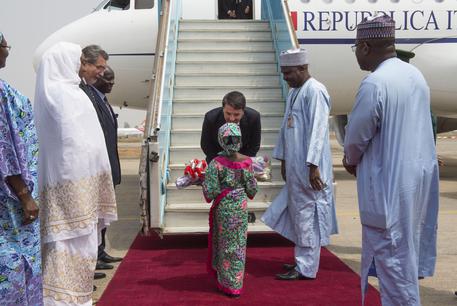 Il presidente del Consiglio Matteo Renzi al suo arrivo in Nigeria riceve un omaggio floreale da una bambina nigeriana ad Abuja ANSA/ US PALAZZO CHIGI © ANSA