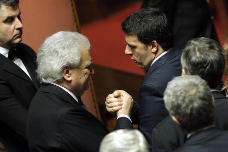 Il presidente del Consiglio Matteo Renzi stringe la mano a Denis Verdini (archivio) © ANSA