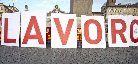 Uno striscione con la scritta 'Lavoro' mostrato in piazza Montecitorio, archivio © ANSA