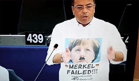 Buonanno con la maglietta 'Merkel  Failed' ha fallito e sopra la scritta il viso della cancelliera tedesca solcato da due baffetti  alla Hitler. © ANSA