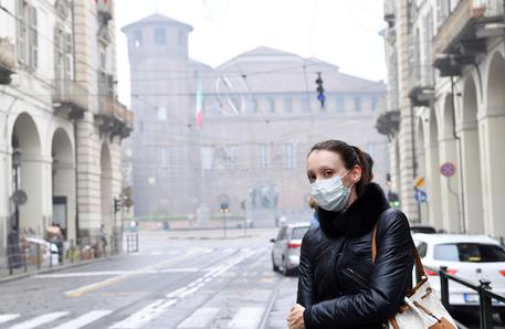 Una ragazza indossa la mascherina per l'alto livello di smog a Torino, 20 ottobre 2017 © ANSA