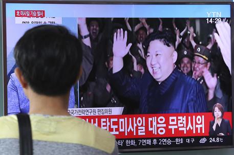 Un uomo guarda un programma che mostra Kim Jong Un in una foto d'archivio © AP