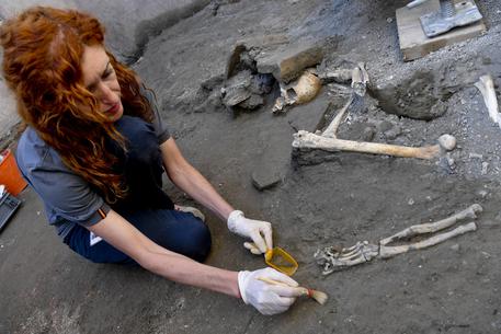 A Pompei ritrovati cinque nuovi scheletri. l'antropologa del team al lavoro nella casa dell'iscrizione (foto CIRO FUSCO ANSA) © ANSA