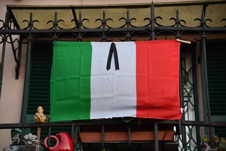 Bandiera listata al lutto a Genova © ANSA