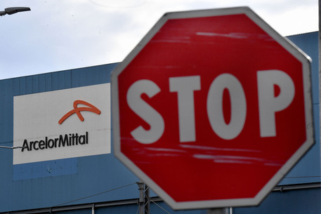 La scritta della Acelor Mittal sullo stabilimento siderurgico ex Ilva  di Genova Cornigliano © ANSA
