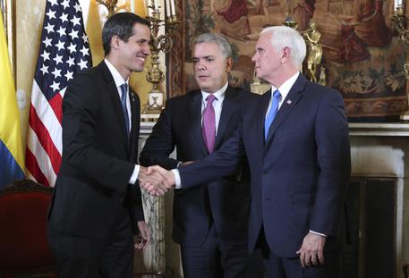 Juan Guaido, a sinistra, stringe la mano al vice presidente Usa Mike Pence © AP