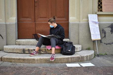 Una delle due studentesse di Torino che stanno protestando con il banco in strada contro la dad © ANSA
