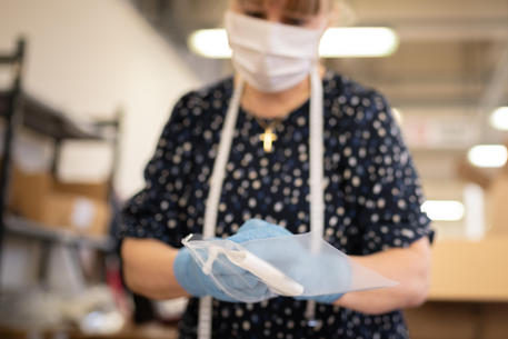 Una donna al lavoro con guanti e mascherine © 