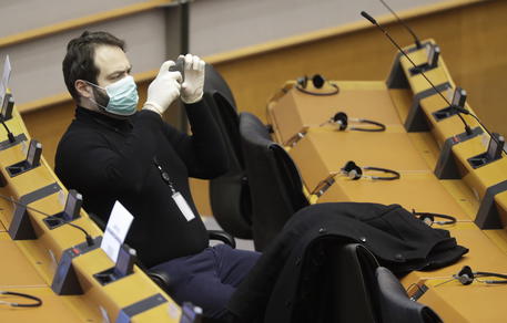 Un membro dell'Europarlamento durante una seduta indossa una mascherina di protezione © EPA
