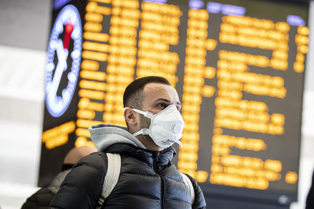 Un uomo con una mascherina in una stazione © ANSA