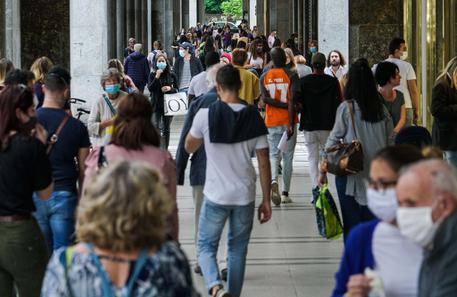 Persone passeggiano e discutono sotto i portici di via Roma, Torino © ANSA