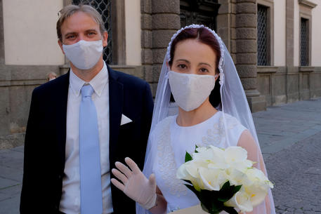 Fase 2.  Padova, sposa  sfoggia l'abito bianco e la mascherina di pizzo, realizzata da lei stessa © ANSA