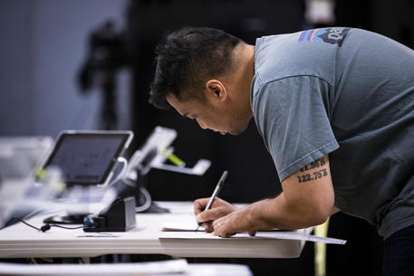 Un elettore si registra per votare in un seggio elettorale a Los Angeles, archivio © ANSA 