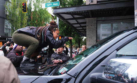 Una manifestante salita su un'auto durante un corteo a Seattle. Foto d'archivio © EPA