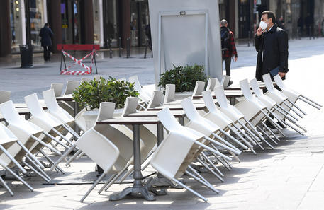 Le sedie vuote e piegate di un bar a Milano © ANSA