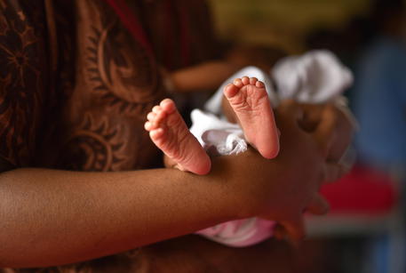 Una donna con in braccio un neonato © EPA