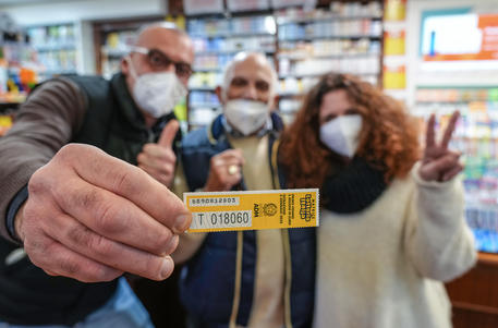 I proprietari della tabaccheria di viale Mazzini con la matrice del biglietto vincente che ieri sera  si è aggiudicato il primo premio della Lotteria Italia da 5 milioni di euro © ANSA