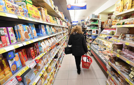 Una persona fa la spesa al supermercato © ANSA