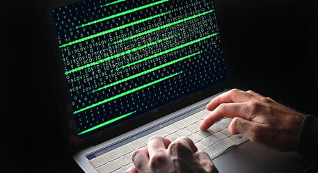 Un'immagine che simula e rappresenta la figura di un hacker impegnato in un attacco informatico © ANSA