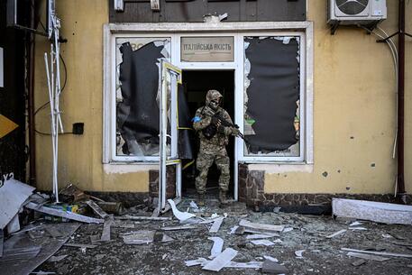 Militare ucraino in un edificio danneggiato dai bombardamenti a Kiev © AFP