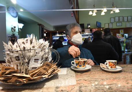 Un uomo con la mascherina in un bar, archivio © ANSA