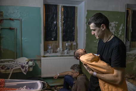 Un padre culla il suo bimbo nato da poco nell'ospedale di Kiev © ANSA