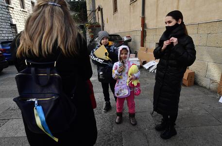 Bambini in attesa davanti al centro di ascolto Caritas a Genova © ANSA