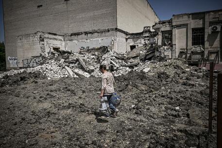 Una donna cammina in un villaggio del Donbass © AFP