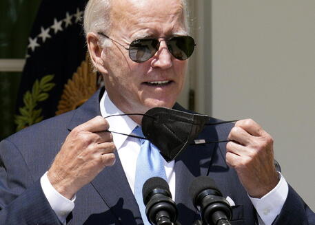 Il presidente americano Joe Biden in una foto d'archivio mentre si toglie una mascherina protettiva © EPA