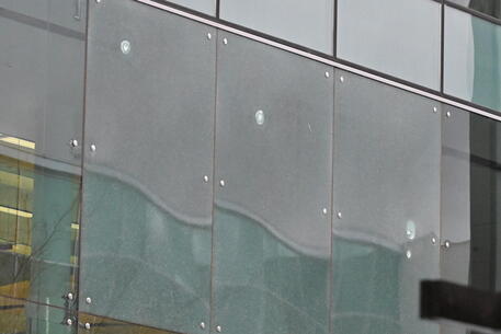 I fori di proiettile sulle vetrate dell'aeroporto di Canberra © EPA
