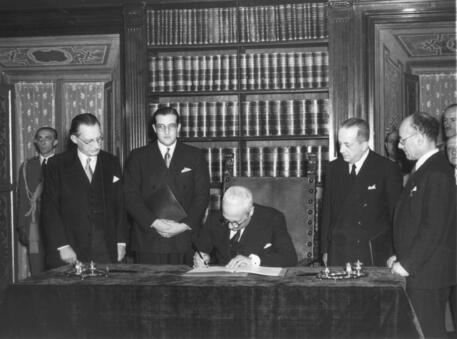 Foto da archivio. Il capo provvisorio dello Stato Enrico De Nicola (c), alla presenza di Alcide de Gasperi (s) e Umberto Terracini (primo a destra) firma il testo della Costituzione entrata in vigore l'1 gennaio 1948 © ANSA