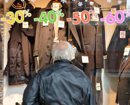 Un uomo osserva i prezzi di un negozio © ANSA