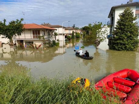 Due cittadini aiutano i soccorsi con la canoa a Faenza. ANSA/ TOMMASO ROMANIN © ANSA