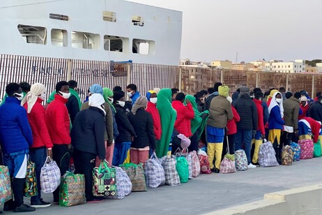 Migranti in fila per essere trasferiti a Porto Empedocle, Lampedusa