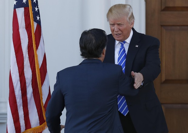 Trump saluta Romney al suo arrivo all'incontro (foto: AP)