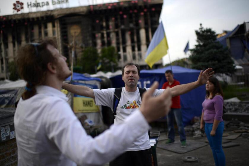 Ukrainian men pray at the Maidan Square in downtown Kiev, Ukraine, 23 May 2014 © ANSA/EPA