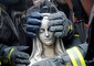 Le mani dei vigili del fuoco proteggono la statua della Madonna rimossa dalla facciata pericolante della chiesa di Paganica (L'Aquila) recuperata dalle macerie del terremoto del 6 aprile 2009 © Ansa