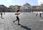 Una ragazza corre in Piazza del Plebiscito a Napoli con la mascherina © Ansa
