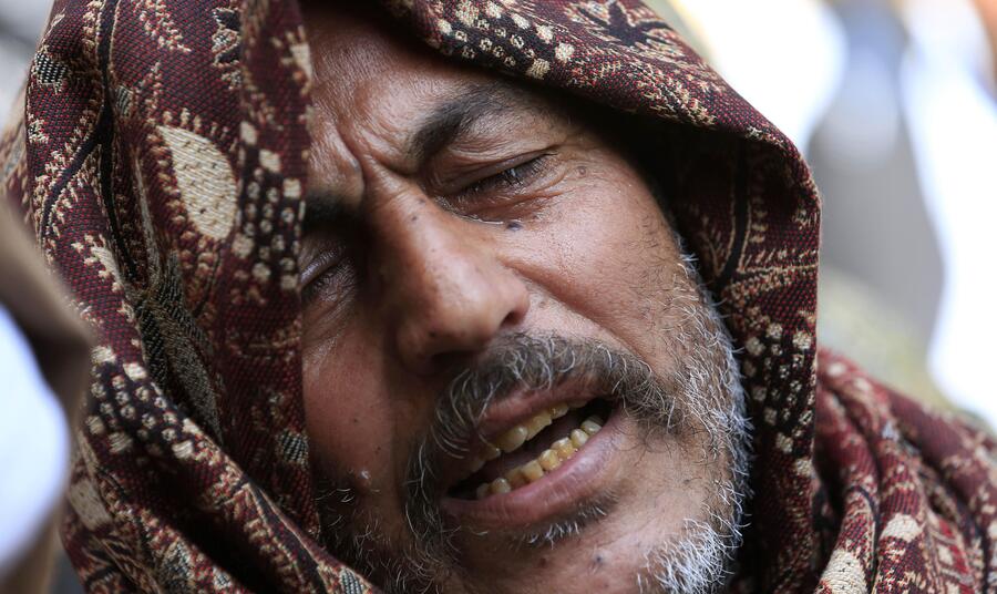 Il dolore di un uomo per i cristiani copti uccisi in Libia © Ansa