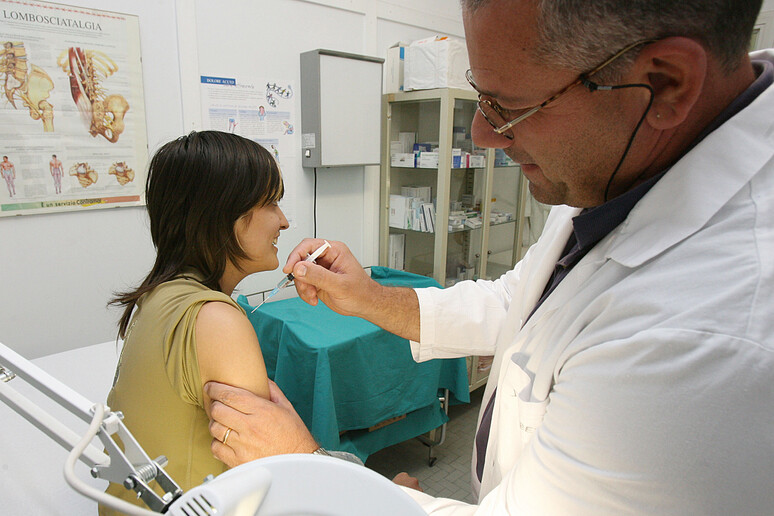 Una dottore vaccina una donna - RIPRODUZIONE RISERVATA