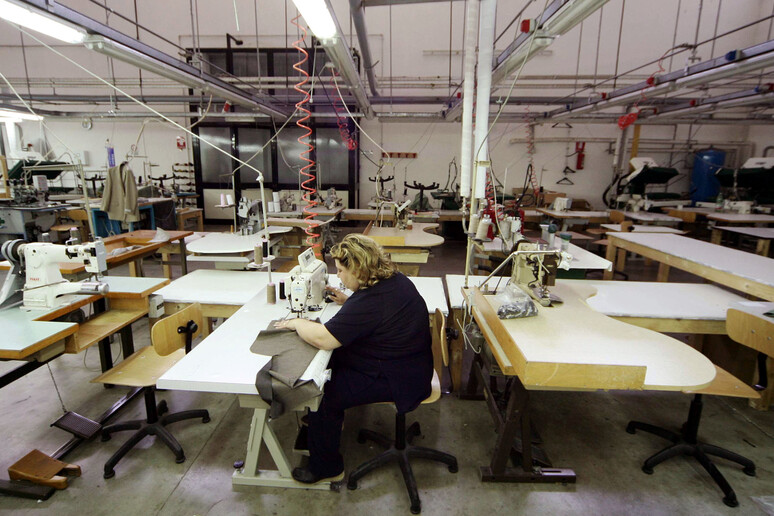 Un ' operaia al lavoro in un 'impresa tessile di Grumo Nevano (Napoli) in una foto di archivio - RIPRODUZIONE RISERVATA