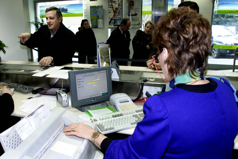 Un 'impiegata ad uno sportello bancario in una foto d 'archivio - RIPRODUZIONE RISERVATA
