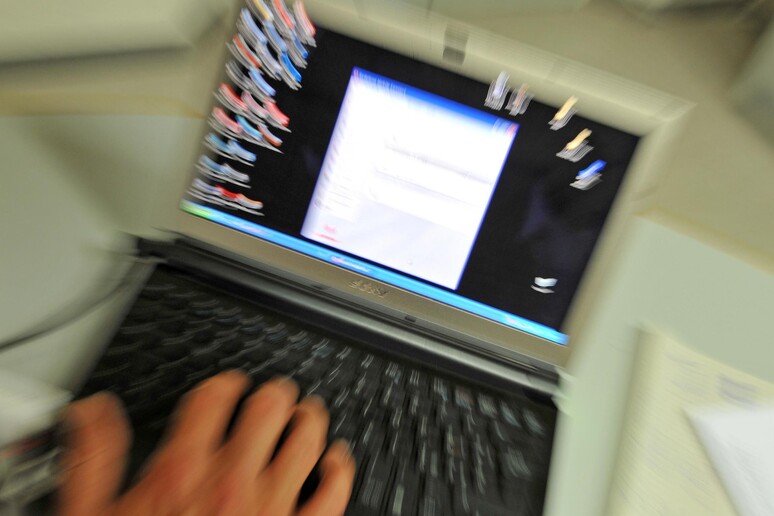 Un uomo utilizza un computer portatile in una foto d 'archivio - RIPRODUZIONE RISERVATA