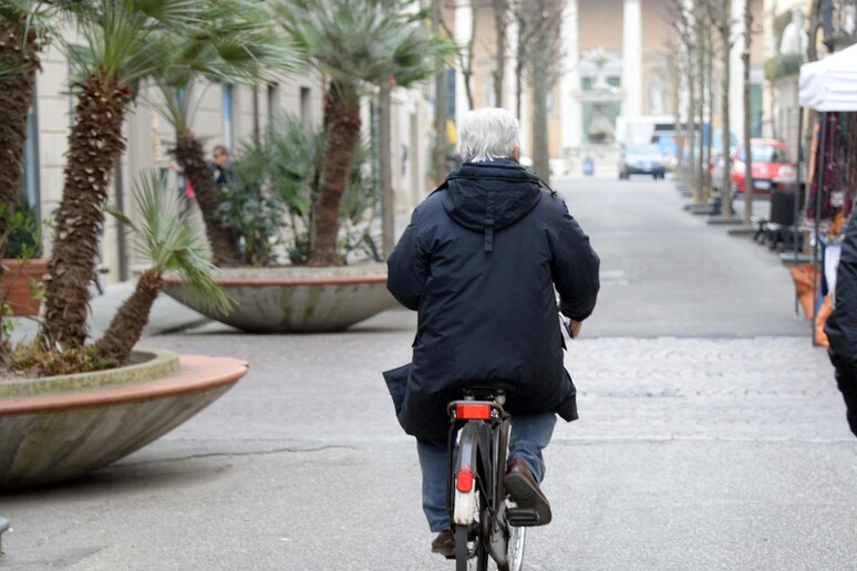 Un uomo anziano in bicicletta - RIPRODUZIONE RISERVATA