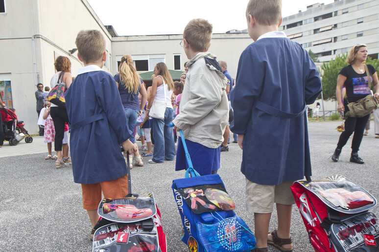 Tre bambini con i loro zainetti pronti ad entrare alla scuola elementare - RIPRODUZIONE RISERVATA