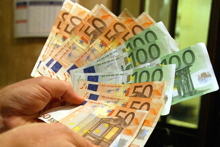 Un uomo tiene in mano alcune banconote di Euro in un 'immagine di archivio - RIPRODUZIONE RISERVATA