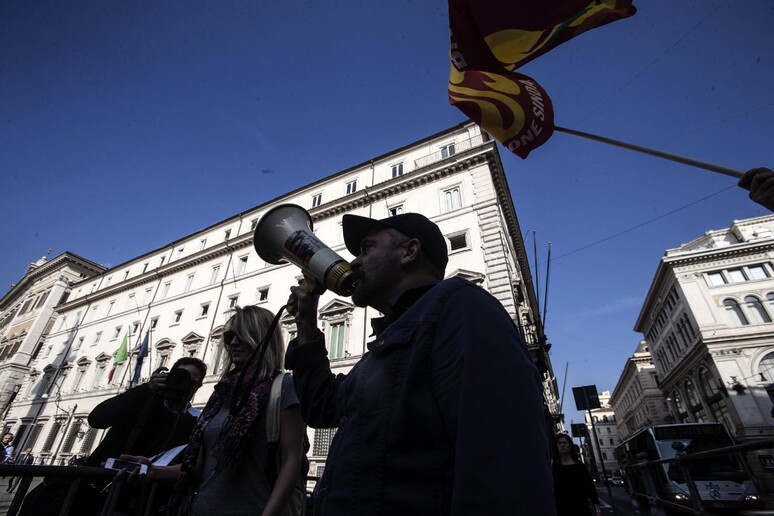 Protesta dei lavoratori davanti palazzo Chigi durante l 'incontro tra il presidente del Consiglio  Matteo Renzi e i sindacati. ANSA-ANGELO CARCONI - RIPRODUZIONE RISERVATA